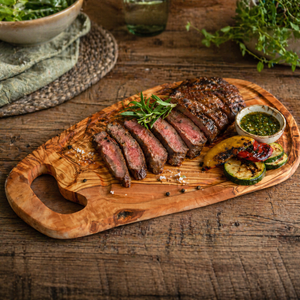 Steakbrett aus Olivenholz mit Saftrille und Fleisch